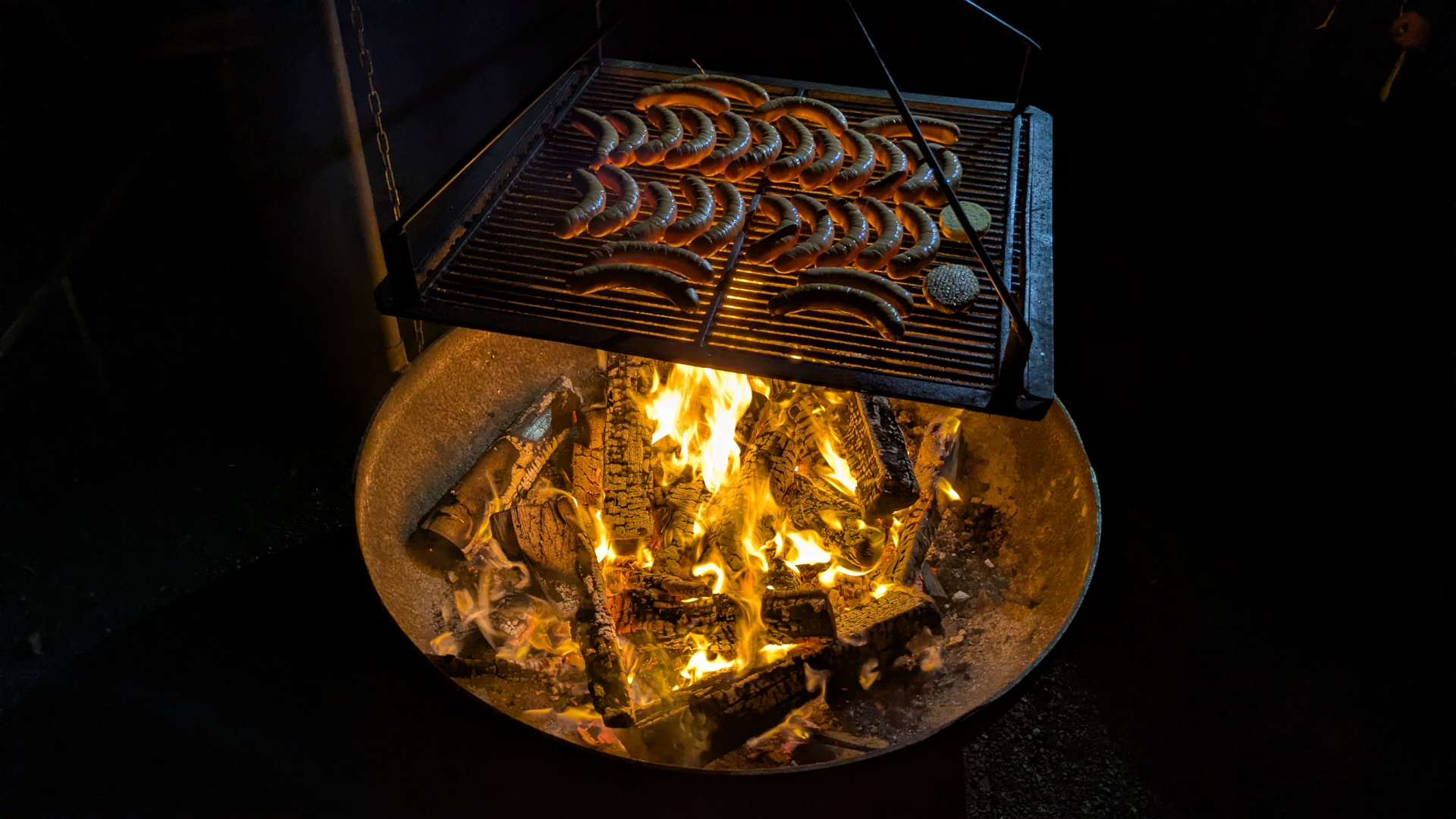 Nächtliches Lagerfeuer mit Roten vom Grill